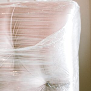 Close-up of a couch wrapped in plastic for protection during moving.